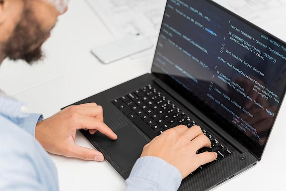 A man using a laptop and writing code.